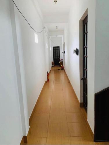 korytarz z białymi ścianami i drewnianą podłogą w obiekcie Nhà Nghỉ Kim Sơn w mieście Hue