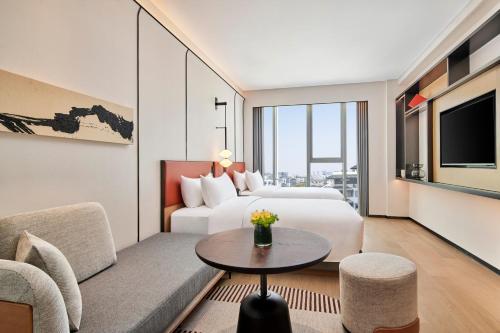 um quarto de hotel com uma cama e um sofá em Artyzen Habitat Suzhou em Suzhou
