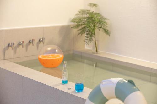 a bathroom with an orange bowl and a bottle of water at Busan H-AVENUE Hotel Seomyeon Station in Busan