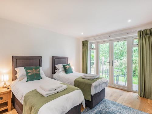 a bedroom with two beds and a window at Dragonfly Den - Uk44530 in Horncastle
