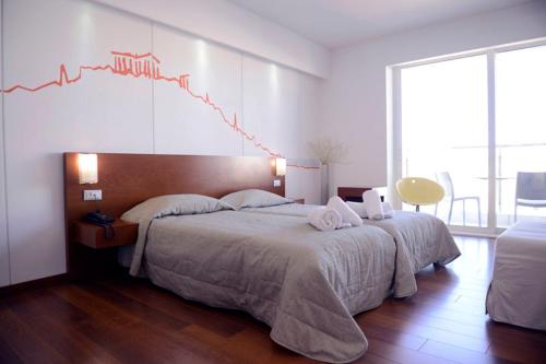 a bedroom with two beds with a chart on the wall at Dorian Inn - Sure Hotel Collection by Best Western in Athens