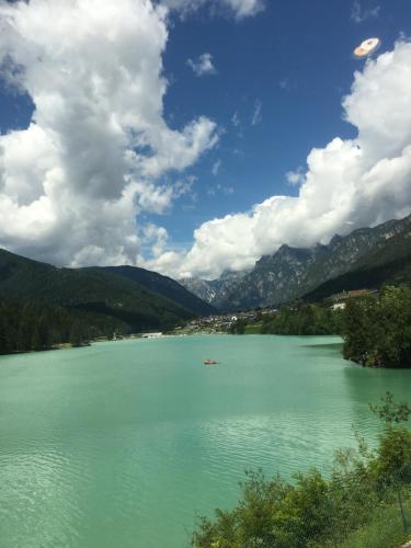 a view of a lake with a boat in it at Hotel Juventus in Auronzo di Cadore