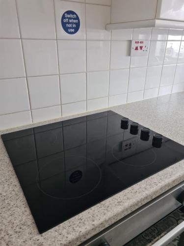 a kitchen counter with a stove top in a kitchen at Comfortable House in South East London in London