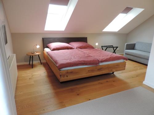 a bedroom with a bed and a couch and skylights at Ferienwohnung-Geltendorf Nähe Ammersee in Geltendorf