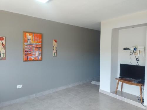 ein Wohnzimmer mit einem Fernseher an einer weißen Wand in der Unterkunft El Bienestar. in San Salvador de Jujuy