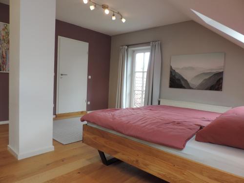 a bedroom with a red bed and a window at Ferienwohnung-Geltendorf Nähe Ammersee in Geltendorf