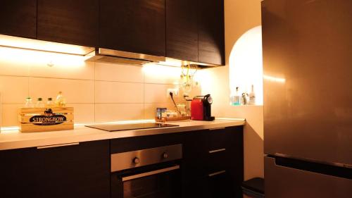 a kitchen with black cabinets and a sink and a stove at Casa na Vila T2 in Fuzeta
