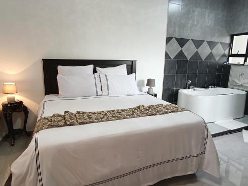 ein Schlafzimmer mit einem großen Bett und einer Badewanne in der Unterkunft Manasseh Guesthouse in Gaborone