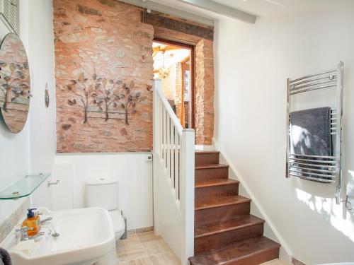 ein Badezimmer mit einer Treppe, einem Waschbecken und einem WC in der Unterkunft Parish Land Barn in Spaxton