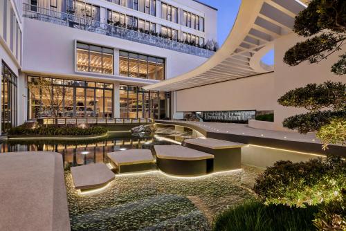 a building with a courtyard with benches and a fountain at Artyzen Habitat Suzhou in Suzhou
