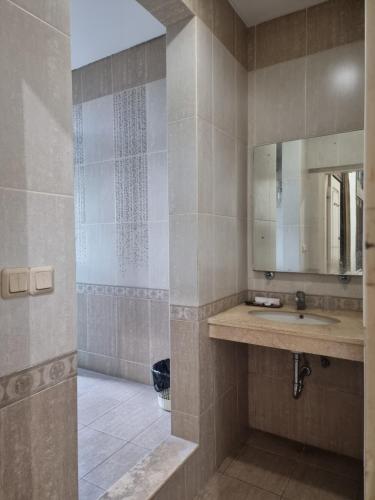 a bathroom with a sink and a mirror at Hotel Candi Baru in Jomblang