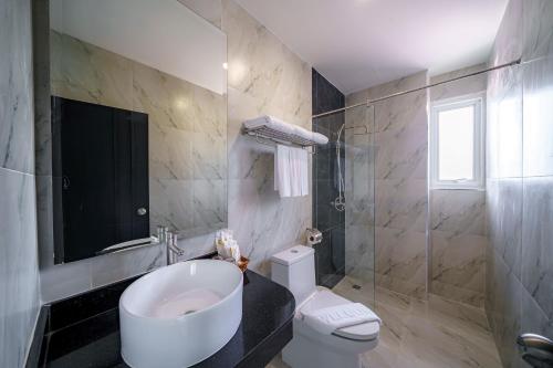 a bathroom with a sink and a toilet and a shower at LHC HOTEL AND RESORT in Pattaya Central