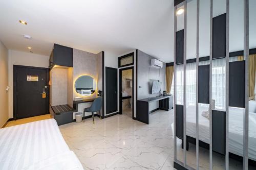 a hotel room with a bed and a desk at LHC HOTEL AND RESORT in Pattaya Central
