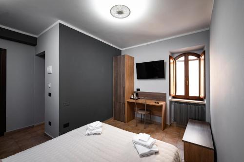 una camera con letto, scrivania e TV di Roof Garden Rooms ad Assisi