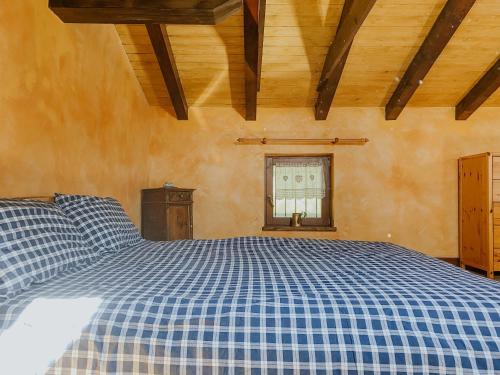 a blue and white bed in a room with a window at Ca’ Ai Monti in Trarego