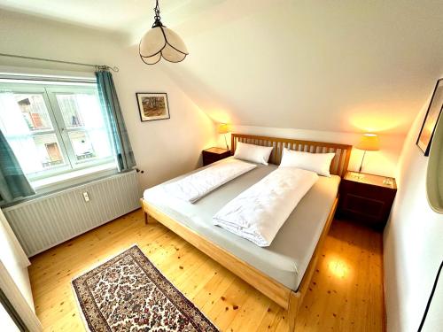 a small bedroom with a bed and a window at Rosi's Ferienwohnung im Haus Sieglinde in Prien am Chiemsee
