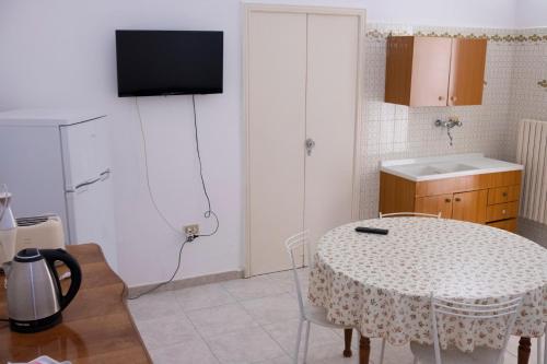 uma cozinha com uma mesa e uma televisão na parede em Casa vacanza “La Maison de famille” em Surbo