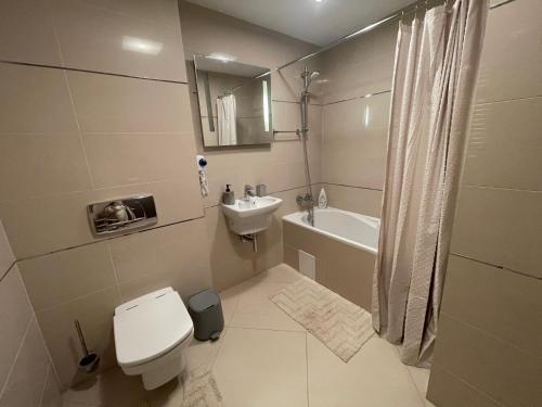 a white bathroom with a toilet and a sink at Luxury Silver Mountain Apartment in Poiana Brasov