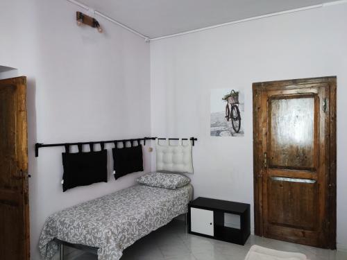 1 dormitorio con 1 cama y puerta de madera en Come a Casa - Like home en Tocco da Casauria