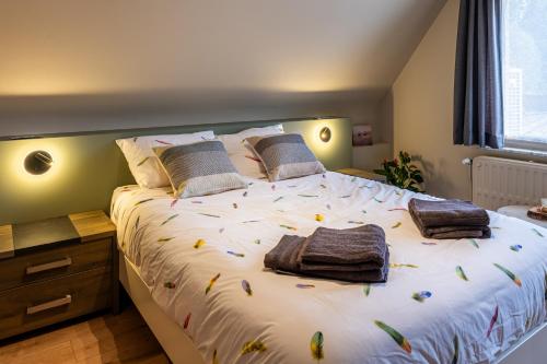 a bedroom with a large bed with towels on it at Séjour14 -- Gastenverblijf - volledige 1e verdiep in Veurne