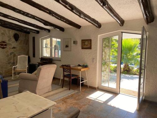 een woonkamer met een bank en een tafel bij Charming cottage, pool & garden by Guincho beach in Aldeia de Juso