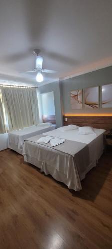 a bedroom with two beds and a ceiling at VOA Hotel Rezende in Lambari