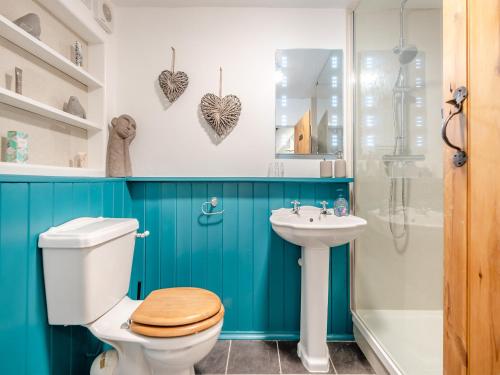 a bathroom with a toilet and a sink at Meadowland in Thornham Magna