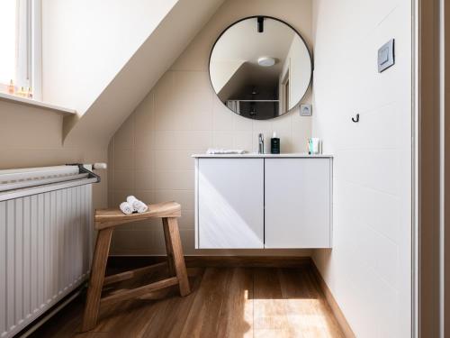 een badkamer met een witte wastafel en een spiegel bij Séjour14 -- Gastenverblijf - volledige 1e verdiep in Veurne
