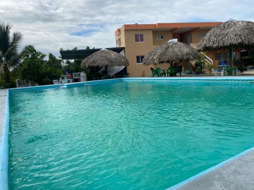 una gran piscina azul junto a un edificio en Rancho el novato, en Concepción de La Vega