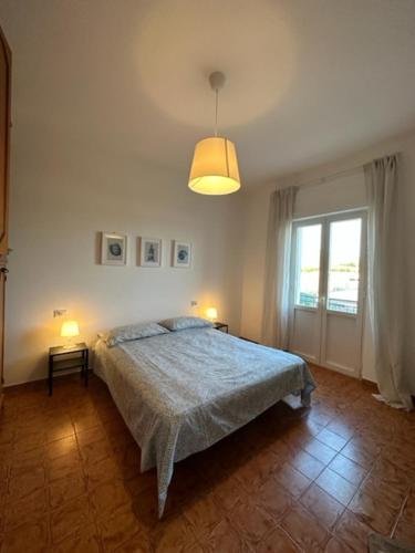 a bedroom with a bed and a large window at Casa Lea - Sperlonga in Sperlonga
