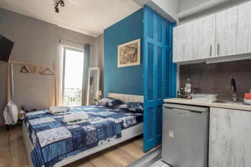 Cet appartement comprend une chambre avec des murs bleus, un lit et une cuisine. dans l'établissement Closer "Penthouse Apartment 1", à Thessalonique