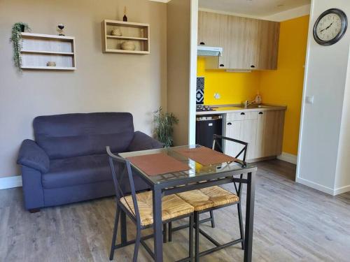ein Wohnzimmer mit einem Tisch und einem Sofa in der Unterkunft La Grelauderie 2 in Saintes