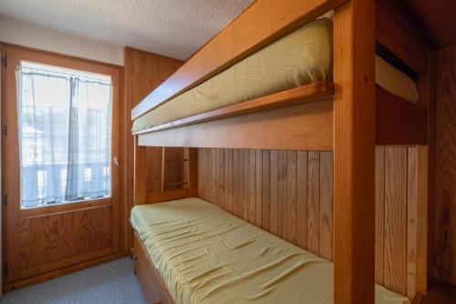 une chambre avec deux lits superposés et une fenêtre dans l'établissement Appartement Prarion Mont Blanc, aux Houches