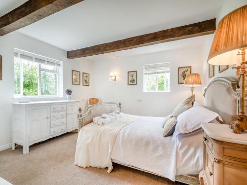 ein weißes Schlafzimmer mit einem Bett und einem Waschbecken in der Unterkunft The Cottage At West Brinsea Farm in Churchill