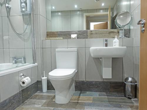 uma casa de banho com um WC branco e um lavatório. em Sail Loft Apartment em Whitby