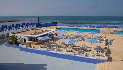 an overhead view of a pool with umbrellas and the ocean at Hotel Tropicana in Casablanca