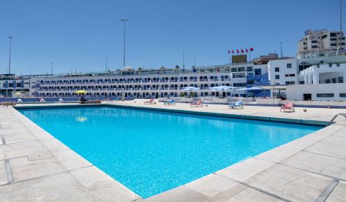 une grande piscine bleue en face d'un bâtiment dans l'établissement hotel tropicana, à Casablanca