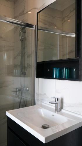 a bathroom with a white sink and a shower at For Rest Aparthotel in St Paul's Bay