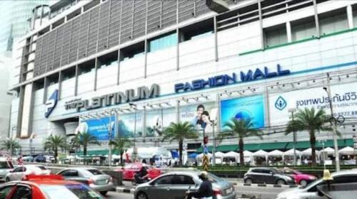 a large building with cars parked in front of it at Cozy 1br walk to BTS and Airport Rail Link Close to Malls T in Bangkok