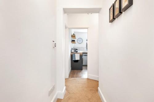 a hallway with a kitchen with white walls at The Limes - Beautiful Townhouse in Oakham in Oakham