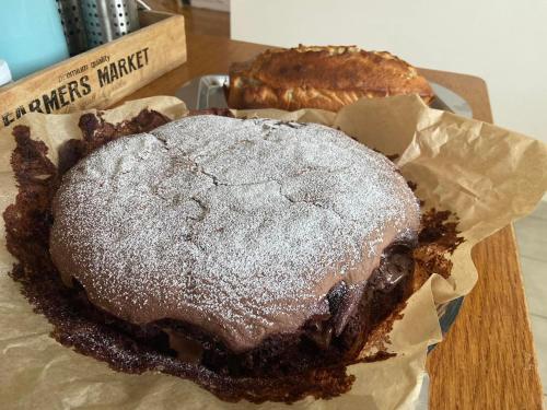 a chocolate pie with powdered sugar on top of it at Très joli appartement équipé au calme in Rozay-en-Brie