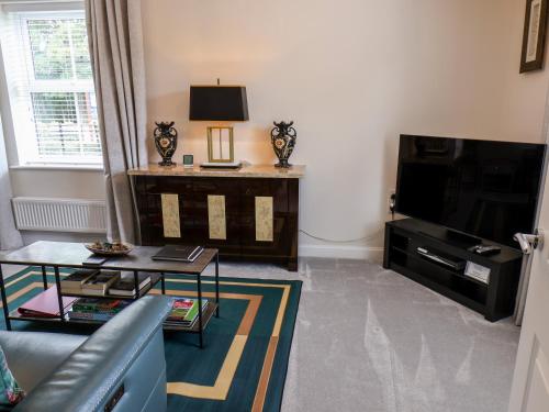 a living room with a couch and a television at Derwent House in Pickering