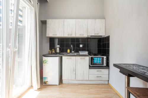 een keuken met witte kasten en een koelkast bij Closer "Egnatia Apartment 2" in Thessaloniki