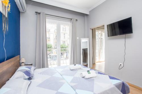 een slaapkamer met een groot bed en een televisie bij Closer "Egnatia Apartment 2" in Thessaloniki