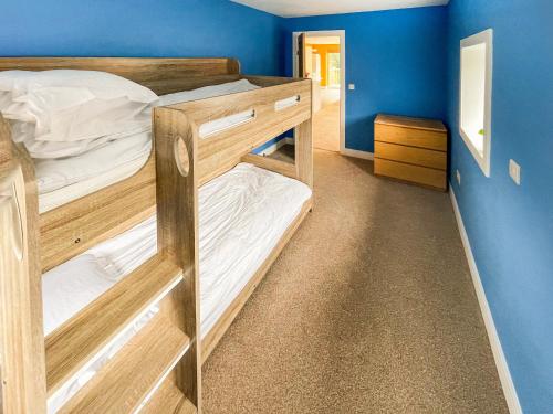 a bedroom with two bunk beds with blue walls at Frankland Farm in Durham