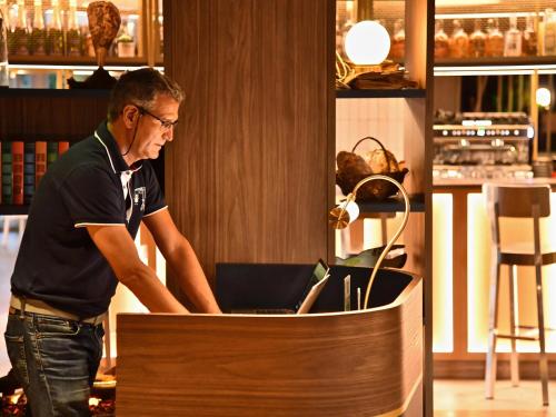 a man standing in front of a desk with a laptop at ibis Styles Nantes Reze Aéroport in Rezé