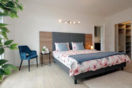 a bedroom with a large bed and a blue chair at Siena Hills Apartments in Siena