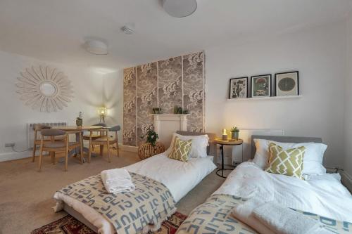 a bedroom with two beds and a table in it at The Limes - Beautiful Townhouse in Oakham in Oakham
