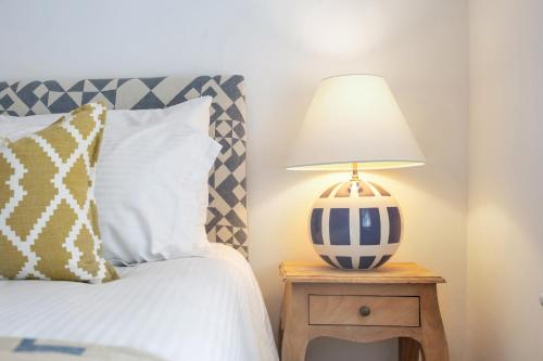 a lamp on a night stand next to a bed at The Limes - Beautiful Townhouse in Oakham in Oakham