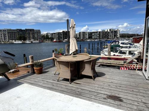 a wooden deck with a table and an umbrella at Unique boathouse. in Copenhagen